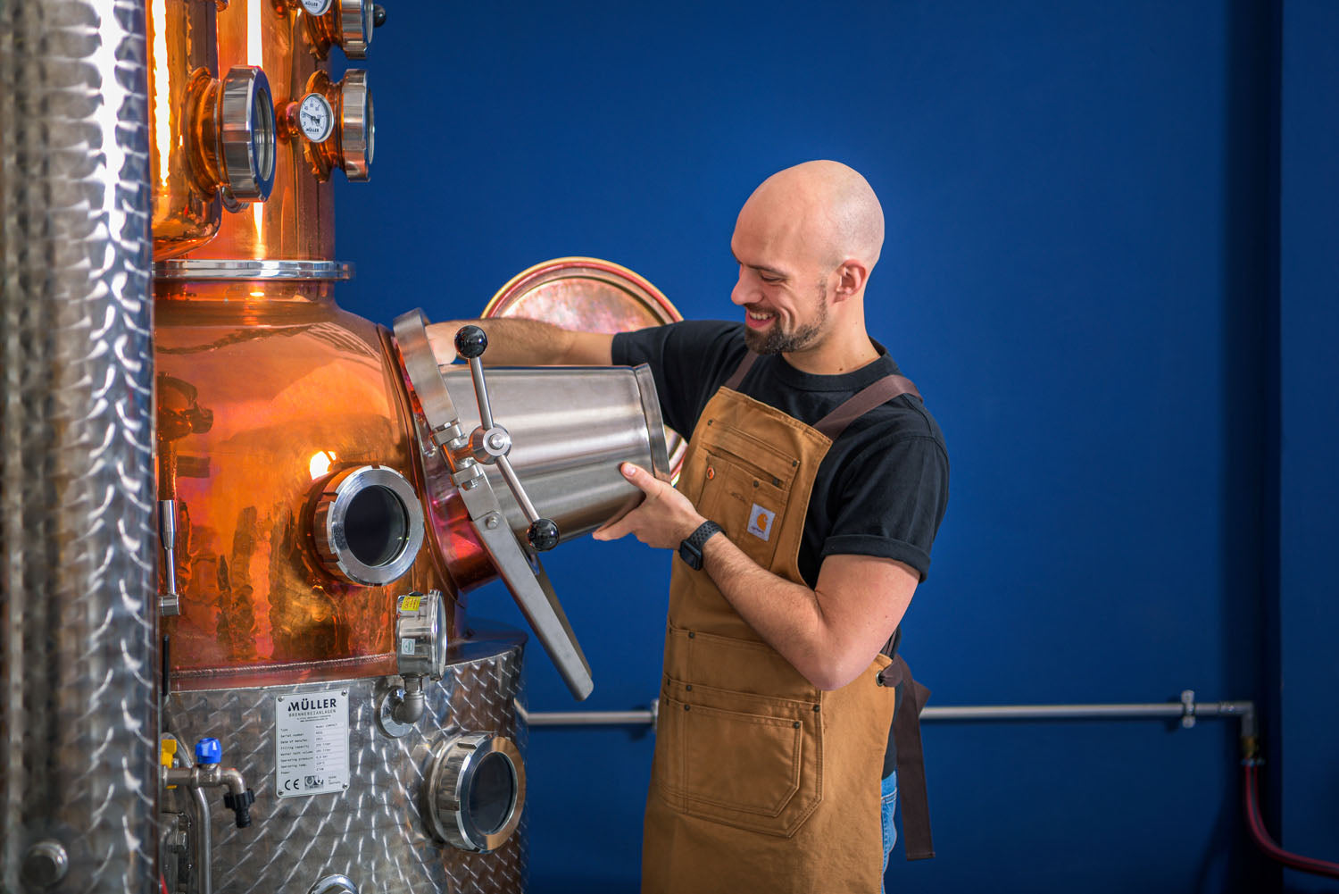 Alex Bartolucci, Master Distiller di Distilleria Mezzanotte, al lavoro sull'alambicco in rame Müller Aroma 230L Percival a Pesaro